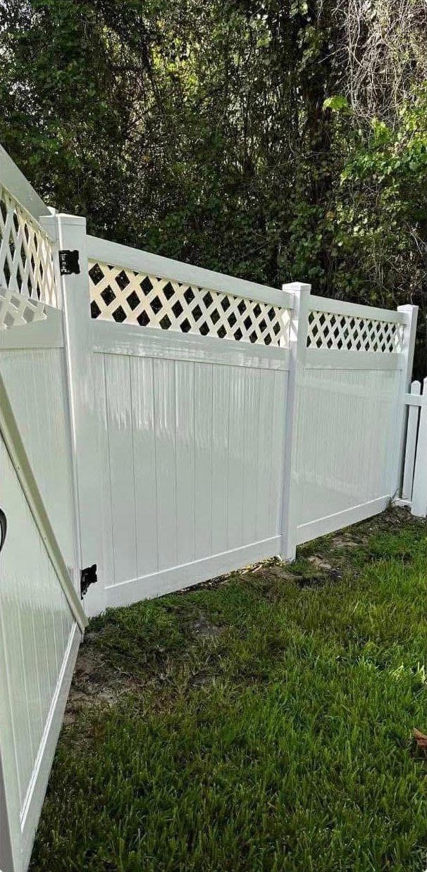 Bright white vinyl fence after professional cleaning.